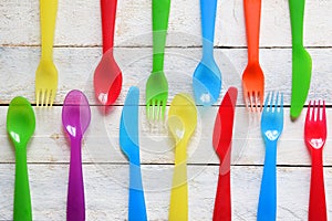 Child cutlery on a white wooden table in a kindergarten. Colorful flatware