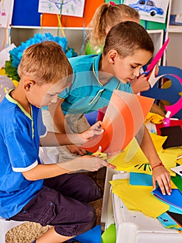 Child cutting paper in class. Development social lerning in school.