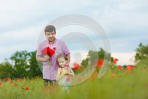 Child with dad picking flowers in poppy field