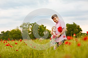 Child with dad picking flowers in poppy field