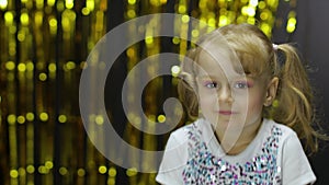 Child dancing, enjoying music, moving in dynamic winning dance. Girl 4-5 years old in shiny t-shirt