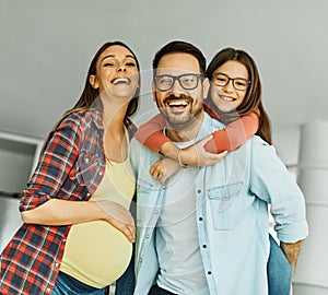 child daughter family happy father piggyback playing fun together girl cheerful smiling home mother pregnant pregnancy