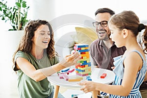 child daughter family happy mother father board game palying playing fun together girl cheerful home