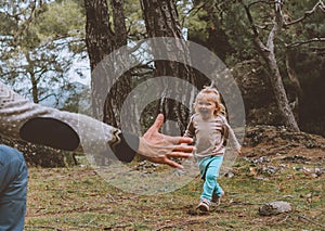 Child daughter running to father happy smiling toddler family walking together in forest