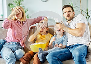 child daughter son family mother father sofa covering eyes, girl boy tv movie entertainment watching television home