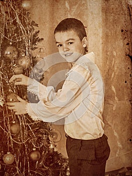 Child decorate on Christmas tree.
