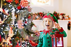 Child decorating Christmas tree. Kid on Xmas eve
