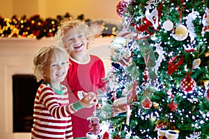 Child decorating Christmas tree. Kid on Xmas eve