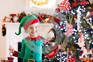 Child decorating Christmas tree. Kid on Xmas eve