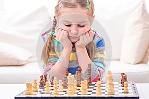 Child is in deep thought about chess winning strategy