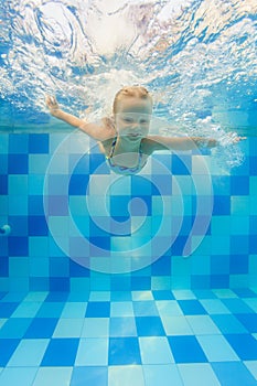 Child dive in pool, jump deep down underwater from poolside