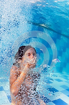 Child diving underwater in swimming pool