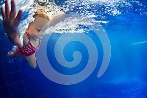 Child diving underwater in swimming pool