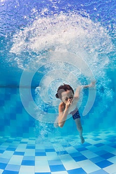 Child diving underwater in swimming pool