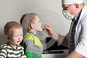 The child doctor examines the patients in his office. Happy children are very fond of a good pediatrician. The concept of a home d photo