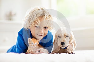 Child, dog and cat. Kids play with puppy, kitten