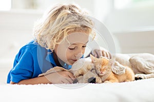 Child, dog and cat. Kids play with puppy, kitten