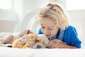 Child, dog and cat. Kids play with puppy, kitten