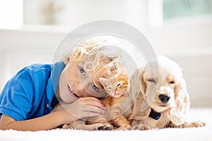 Child, dog and cat. Kids play with puppy, kitten