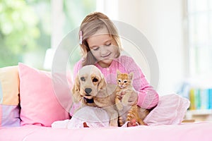 Child, dog and cat. Kids play with puppy, kitten