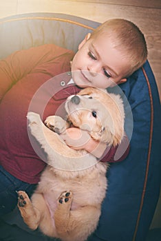 Child, dog and hug with home, floor and pet with love and care at house. Kid, puppy and golden retriever or sleepy