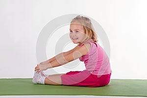 Child is doing exercise exercises on the rug