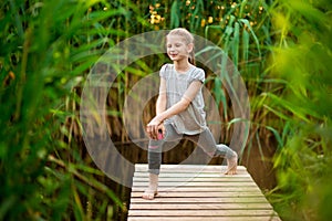 Child doing exercise on platform outdoors. Healthy lifestyle.