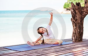 Child doing exercise on platform outdoors. Healthy lifestyle. Yoga girl