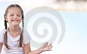 Child doing exercise on platform outdoors. Healthy lifestyle. Yoga girl