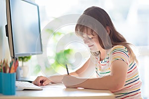 Child doing homework on computer. Online class