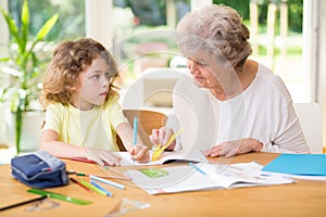 Child doing homework with his grandmother