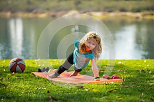 Child doing push-ups exercise outdoors. Healthy kids lifestyle. Children pushing up in park. Lifestyle relaxation