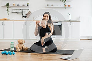 Child doing splits with mother due to online baby yoga class