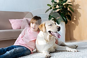 Child with down syndrome hugging Labrador retriever