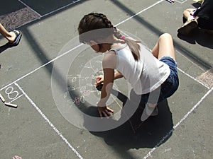 Child drawing on the asphalt chalk