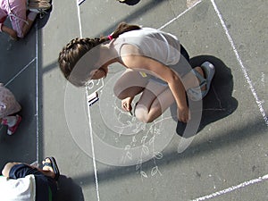 Child drawing on the asphalt w