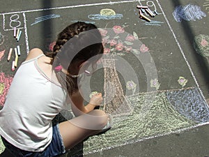 Child drawing on the asphalt w