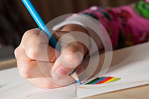 Child drawing with blue pencil