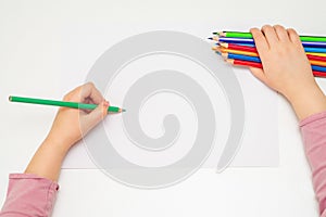 Child is drawing by colored pencils