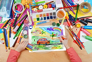 Child drawing dog travel in car , top view hands with pencil painting picture on paper, artwork workplace