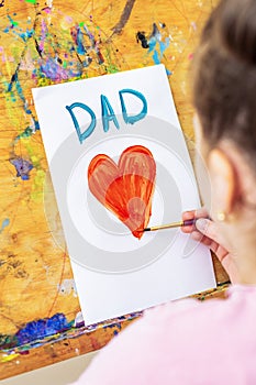 Child is drawing Father`s day greeting card