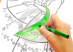 Child drawing with a green wax crayon.