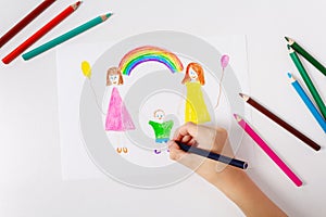 Child drawing his LGBT family. Top view.