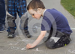 Child drawing on the pavement with chalk