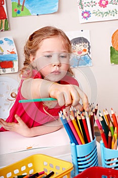 Child drawing pencil in play room.