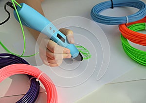 Child draws a 3D pen green leaf.