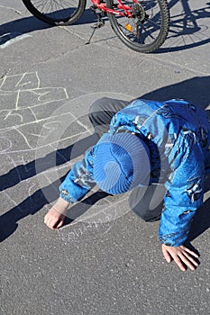 Russia, Severomorsk - 01 May 2018: The boy paints on the asphalt photo