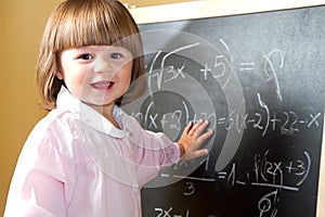 Child draws with chalk on the blackboard