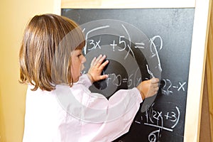 Child draws with chalk on the blackboard