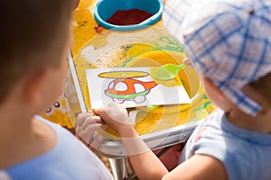 A child draws with colored sand picture. Cartoon characters.